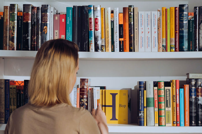 Woman looking through book shelf 