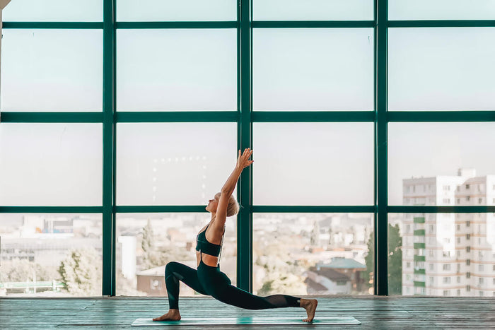 Woman practicing yoga lunges in exotic scenery 