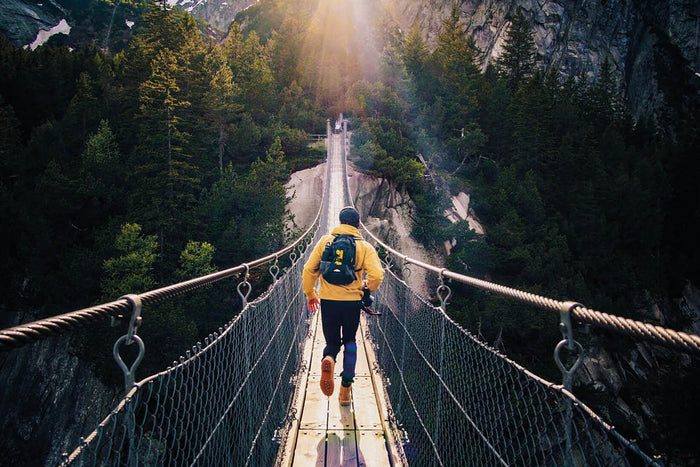 Man hiking over bridge outdoors  