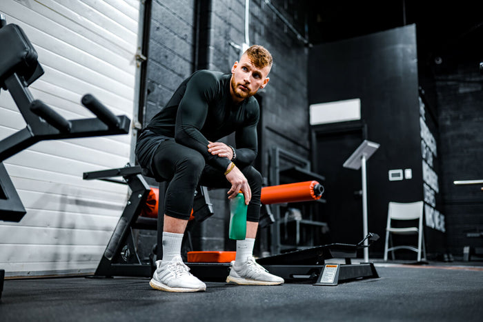 Man sitting on gym equipment 