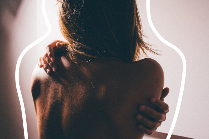 Woman hugging her bare back 