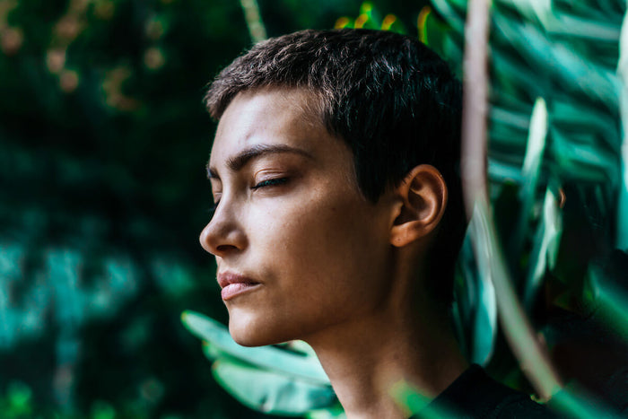 Woman meditating in exotic forest 