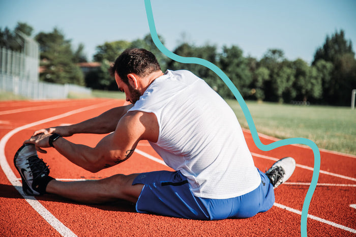 Man stretching on running track