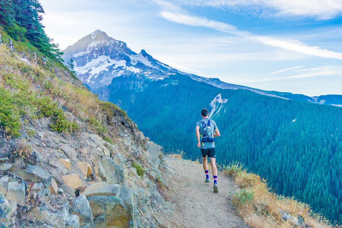 Man running around mountain in sustainable activewear