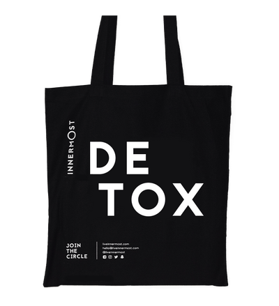 Innermost black cotton tote bag with DETOX printed on it